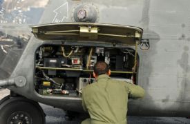 Engineer performs military helicopter maintenance
